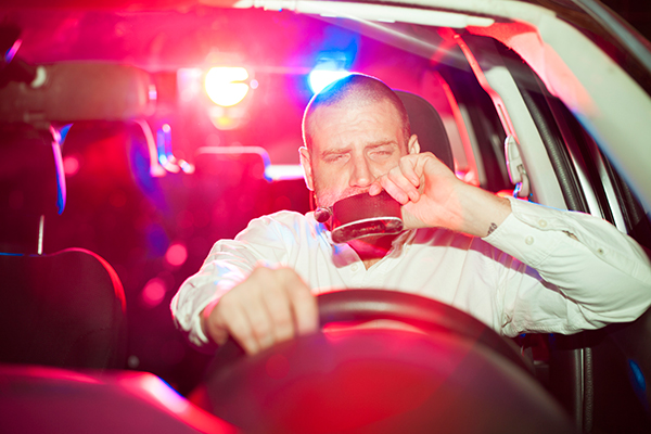 man-drinking-and-driving-and-getting-pulled-over